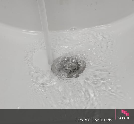 מים זורמים בכיור עם ברז פתוח